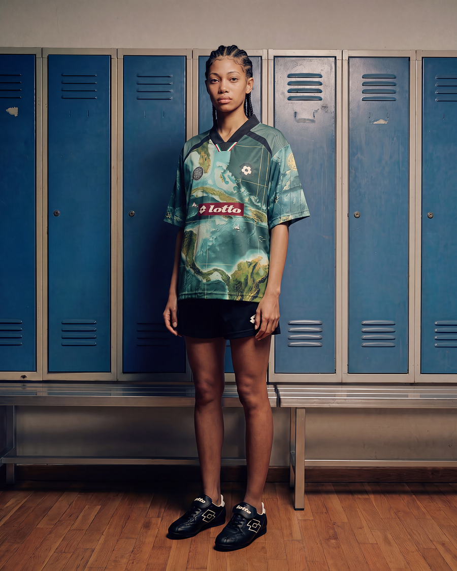 Girl standing in front of a wall of lockers wearing the LOTTO X Joshua Joseph jersey front view